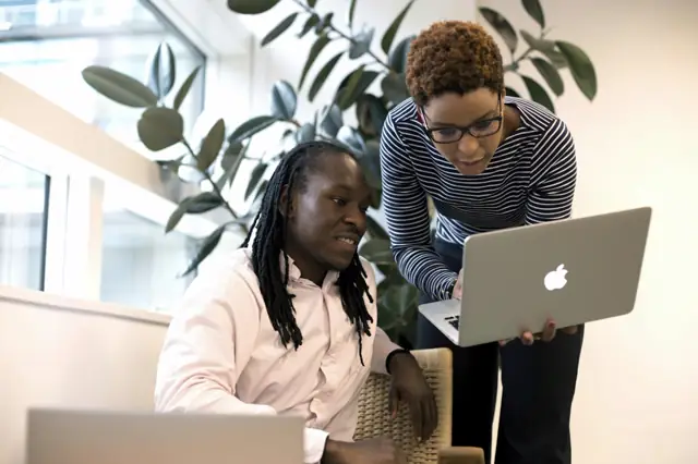 Two colleagues working together on a laptop