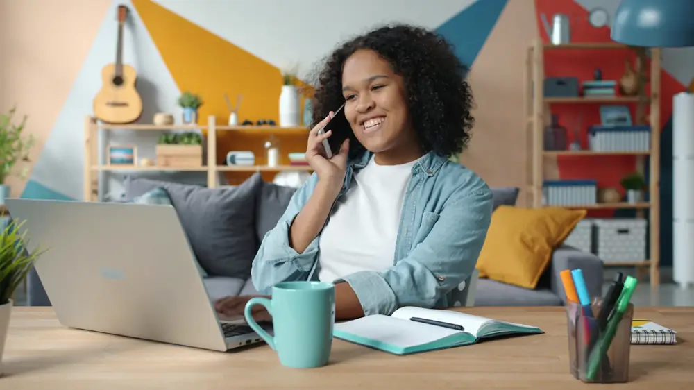 A recruiter smiling on a phone call at her desk